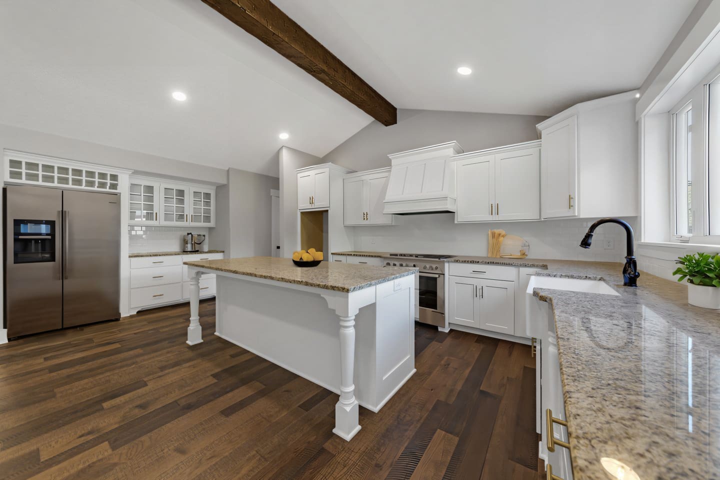 Kitchen with white custom cabinets and an island with furniture legs.